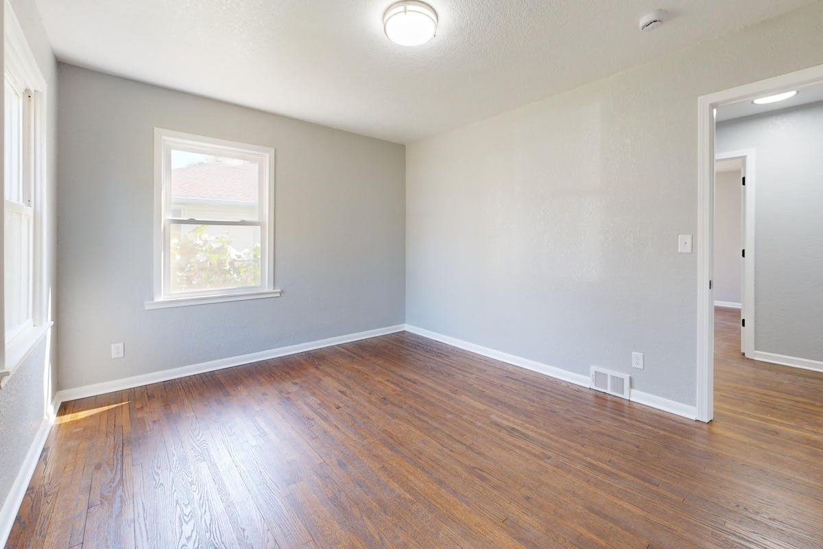 Bright empty room with clean hardwood floors ready for new occupants